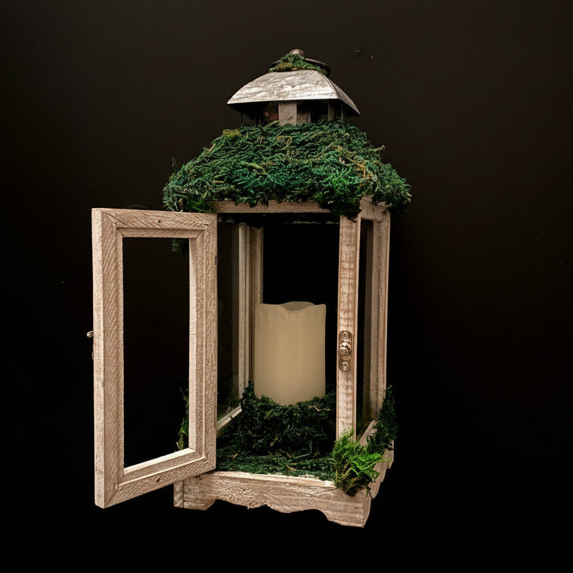 Decorative lantern with moss and a candle on a black background