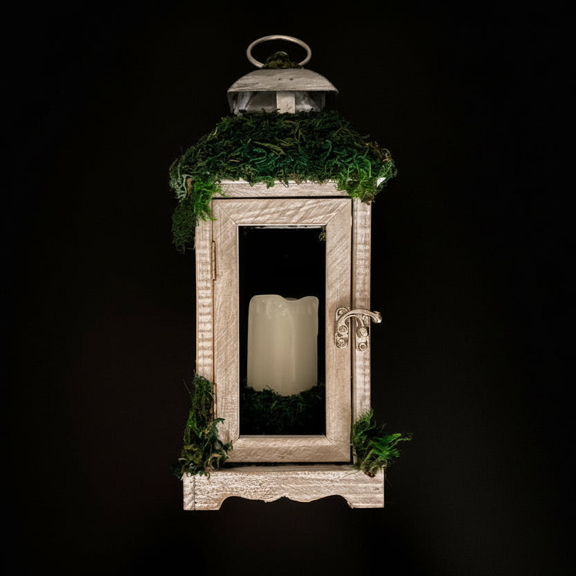 Decorative lantern with a wooden frame and greenery on a dark background
