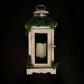 Decorative lantern with a wooden frame and greenery on a dark background