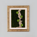 Decorative wall art with green succulents on a dark background, framed in gold.