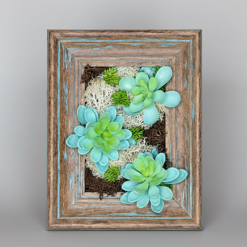 Framed artwork with green succulent plants on a textured wall background