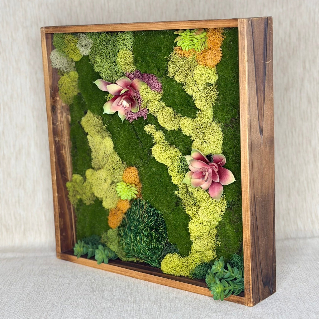 Moss wall art with flowers in a wooden frame on a neutral background