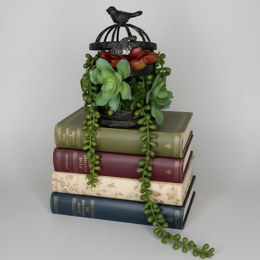 Decorative planter with succulents and a small birdhouse on a neutral background