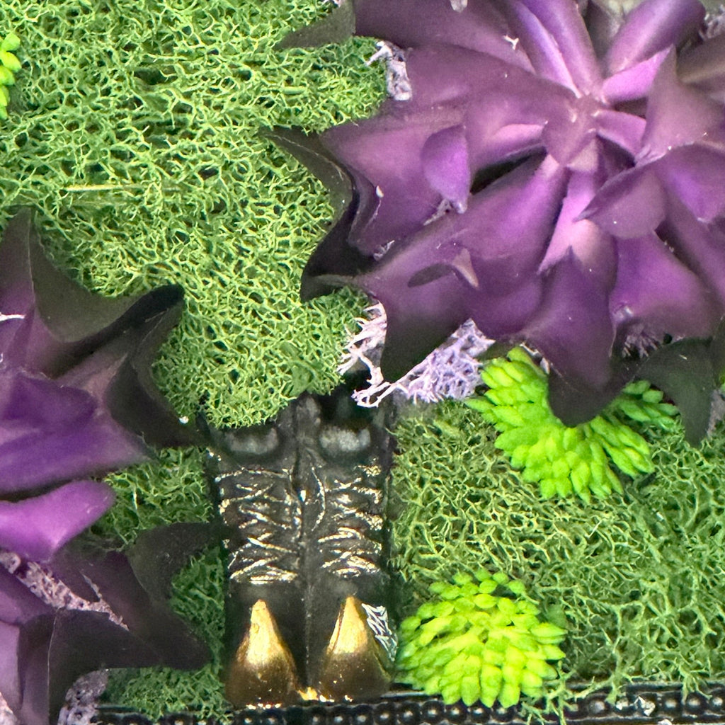 Decorative arrangement with purple flowers and green foliage on a textured surface